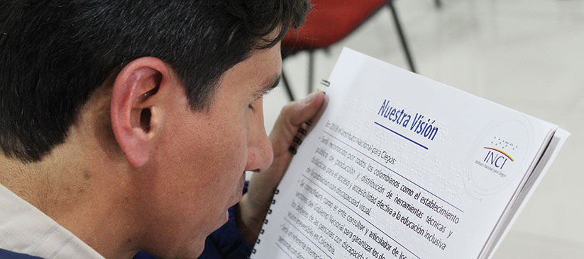 Persona con discapacidad visual leyendo el catalogo de servicios del INCI