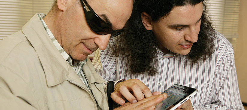 Persona con discapacidad visual escuchando un libro en una tablet