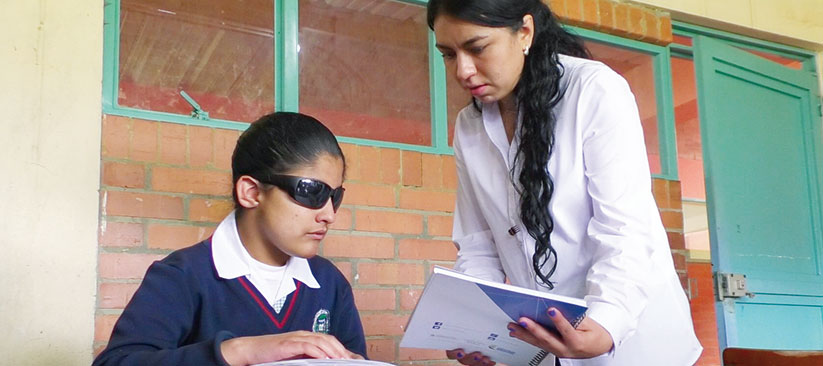 Estudiante recibiendo asistencia técnica en su aula de clase