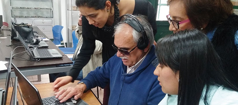 Persona con discapacidad visual recibiendo asistencia técnica en tecnologia
