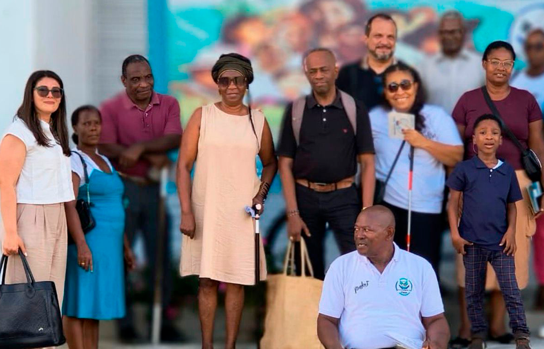 Grupo de personas afrodescendientes y funcionarios del INCI participan en una actividad comunitaria al aire libre, algunas personas utilizan bastón blanco como apoyo para movilidad.