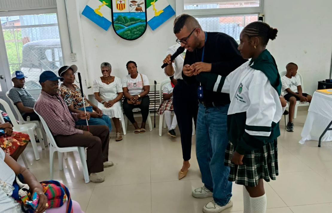 Fabio Leiva, profesional del INCI, realiza junto a una estudiante un ejercicio práctico de técnicas de guía y orientación durante la jornada de asistencia técnica en Istmina.
