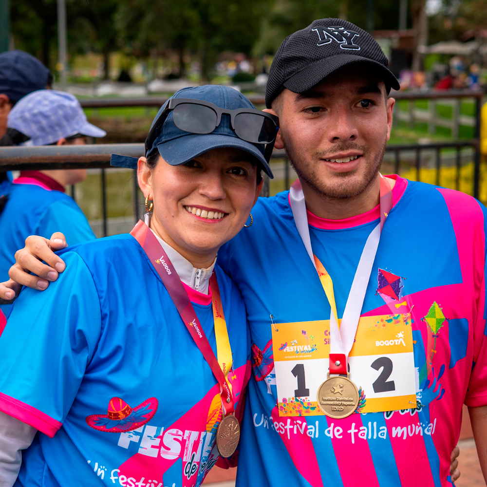 Camilo Garnica y su lazarillo en la carrera 5K Sin Límites posan abrazados con sus camisetas y medallas de la carrera.