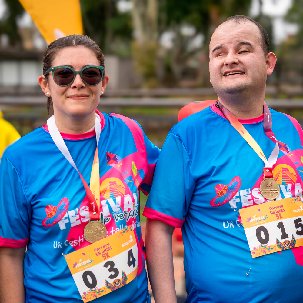 Andrea Carolina Chacón, directora del INCI, y Sergio González posan juntos con sus medallas después de finalizar la 5K Sin Límites.