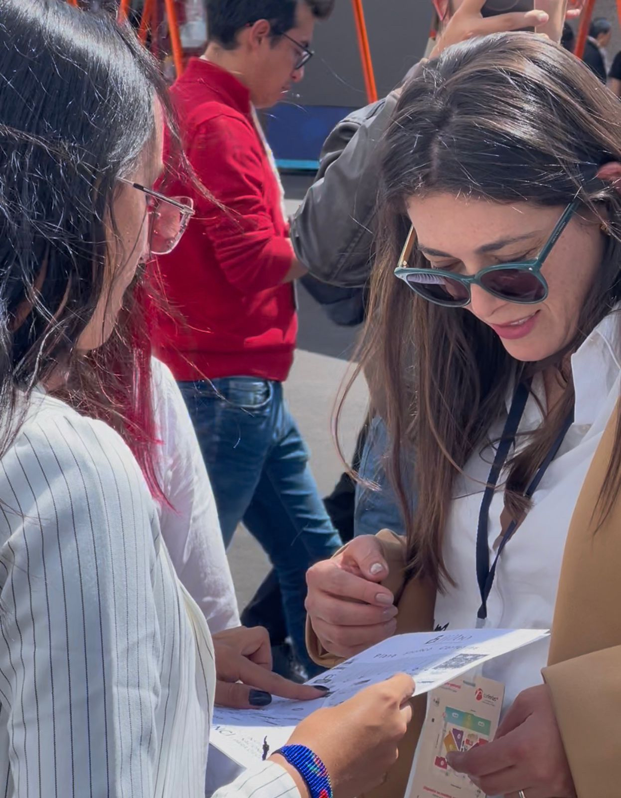 La directora andrea carolina chacón está explicando a una persona quien con sus dedos esta consultando un documento que cuenta con elementos en alto relieve
