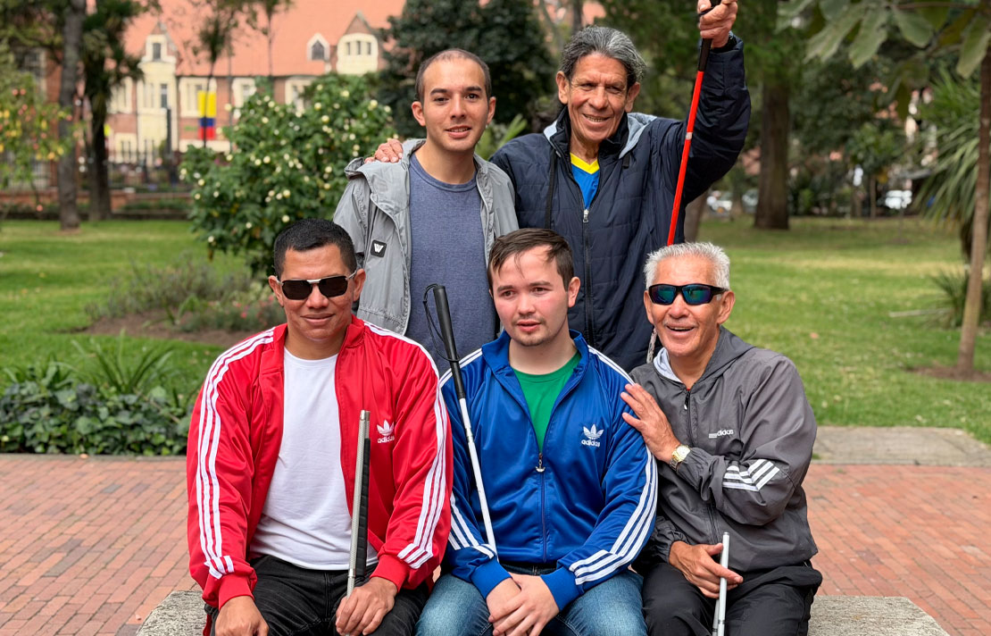 Grupo de personas con discapacidad visual, algunas con bastón blanco, reunidas en un parque durante la jornada de presentación del Run Tour Avianca 2026 en Bogotá