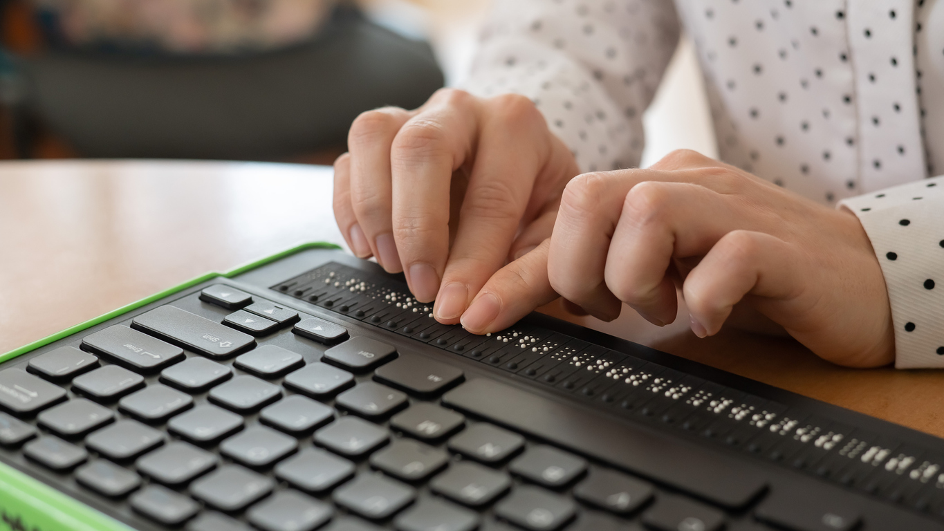 unas manos están sobre una línea braille