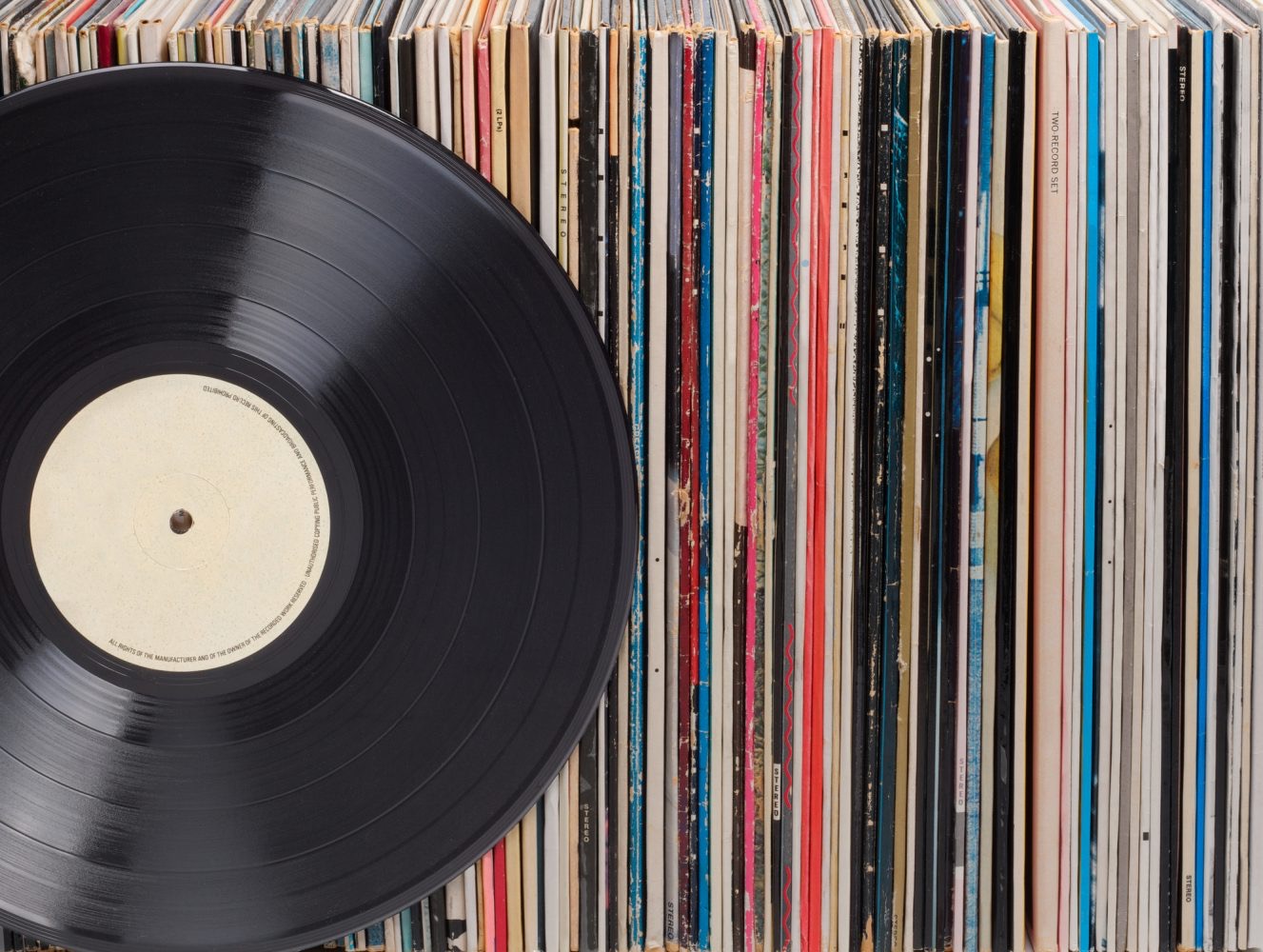 varios vinilos de diferentes generos, en primer plano hay uno sin caratula