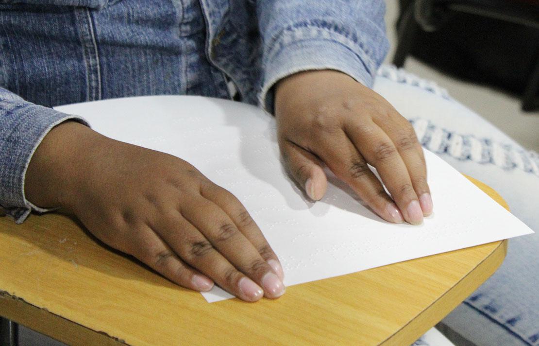 Persona con discapacidad visual leyendo en braille
