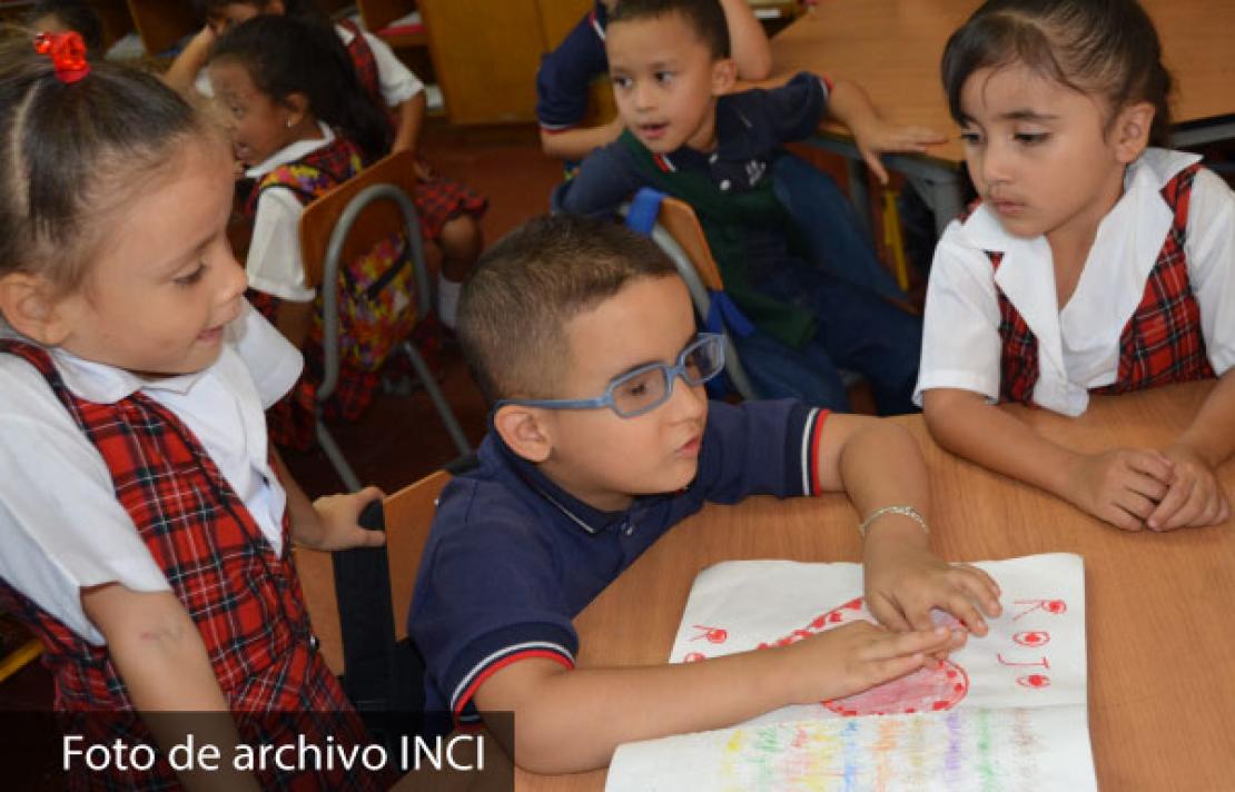 niños con y sin discapacidad apoyándose en el aula de clase