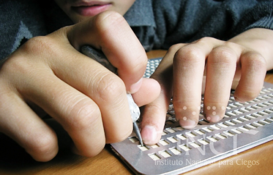 Niño usando una regleta Braille