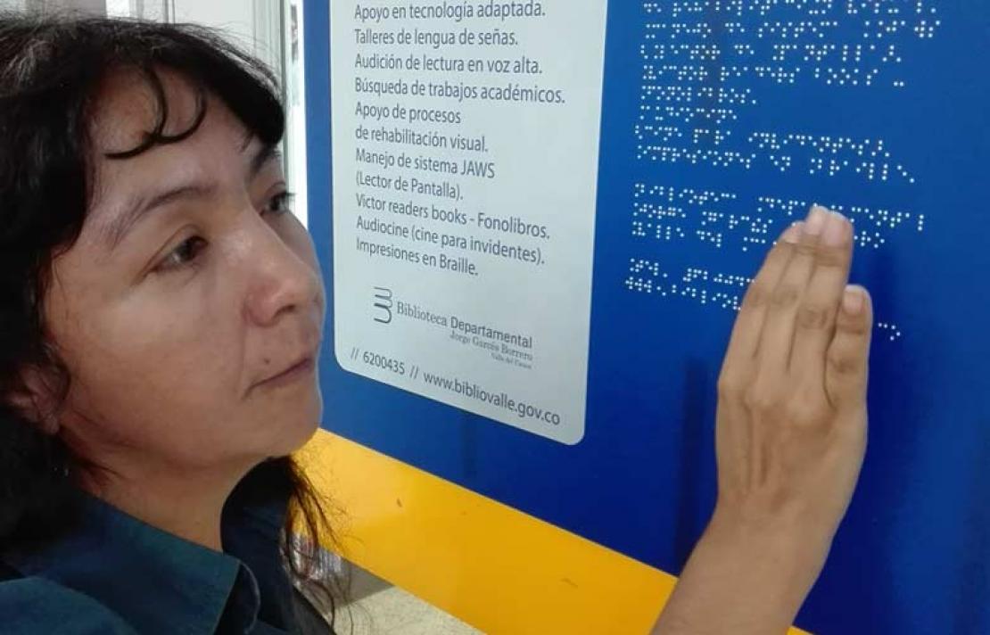 Personas con discapacidad visual, revisando una tableta en braille
