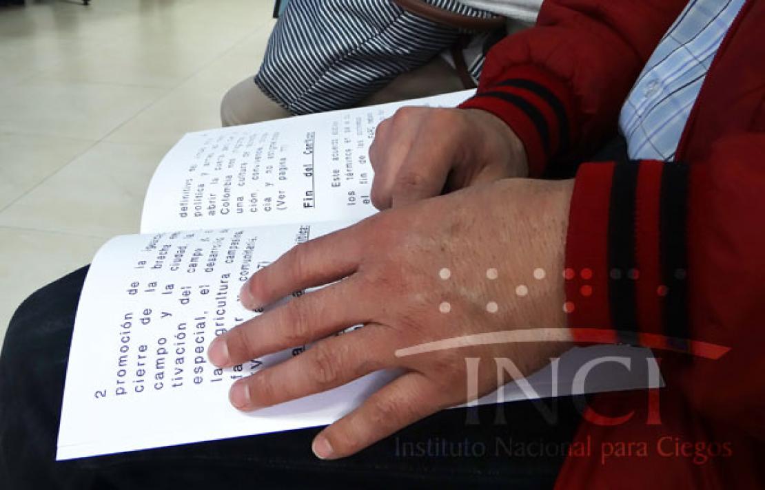 Fotografía Persona con discapacidad visual leyendo en braille