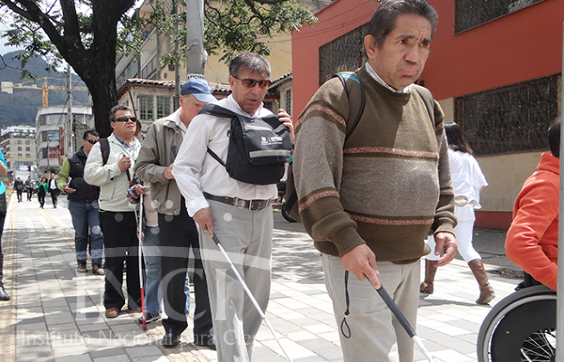 personas con discapacidad visual cruzando una calle concurrida