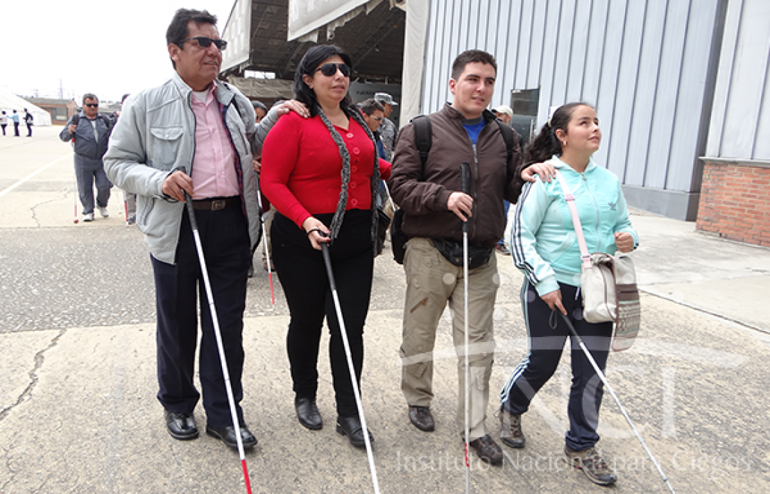 cuatro personas con discapacidad visual caminando con su baston