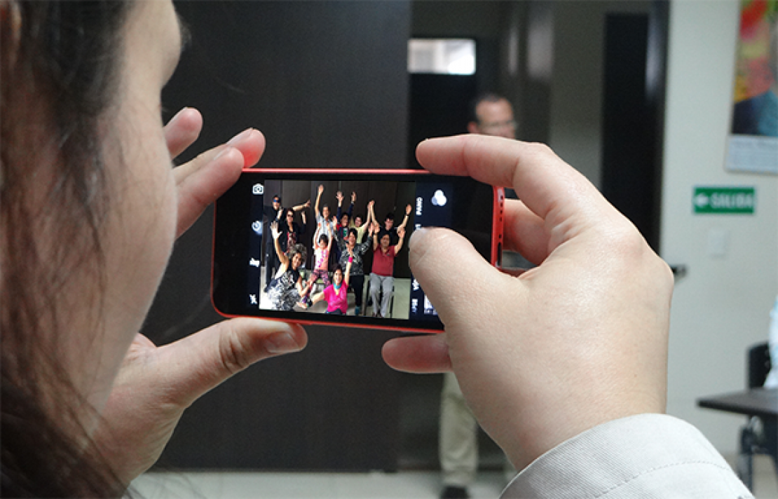 una mujer tomando una fotografía a un grupo de personas con discapacidad visual