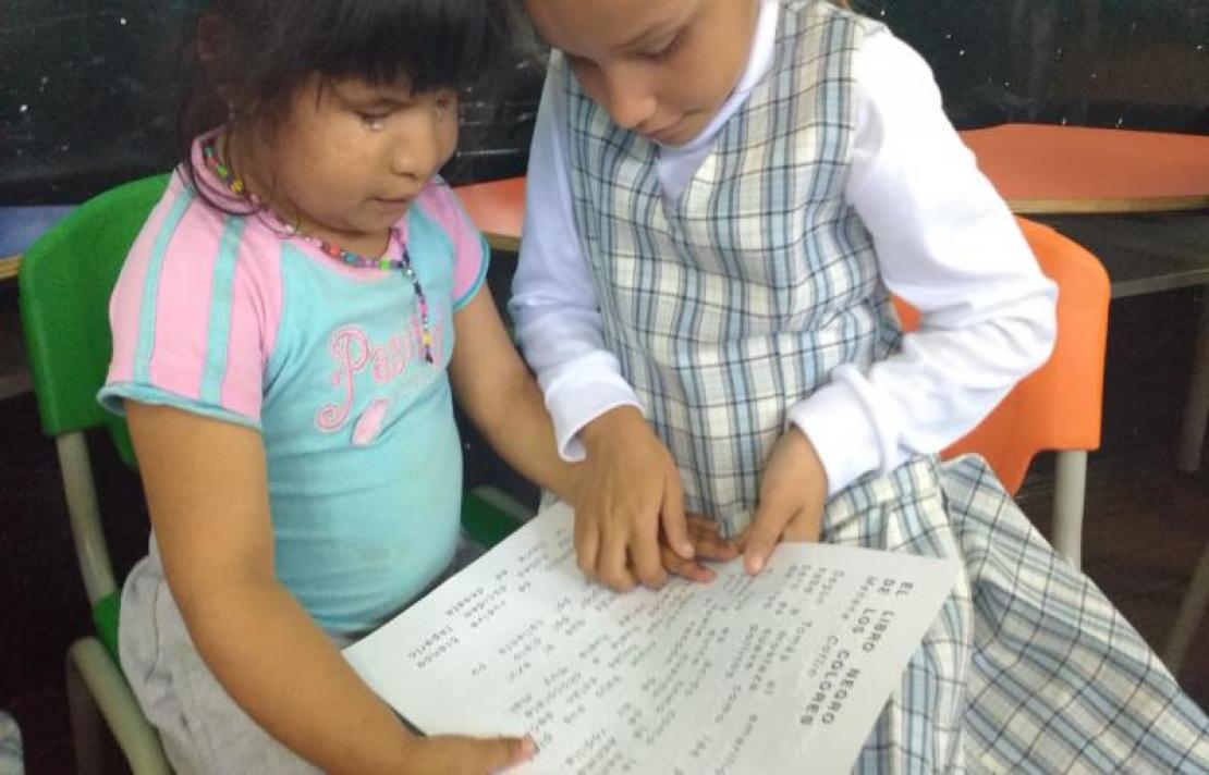dos niñas aprendiendo a leer en braille