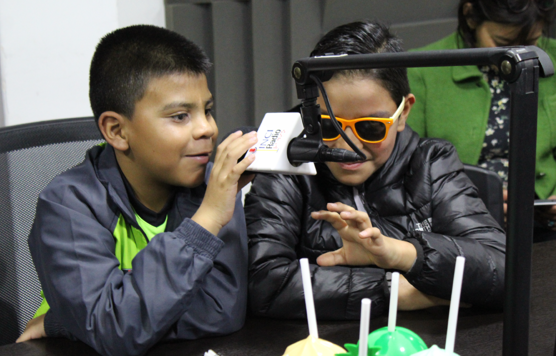 Niños ciegos emisora niños con discapacidad visual en la cabina de inciradio uno de ellos sostiene con su mano un micrófono