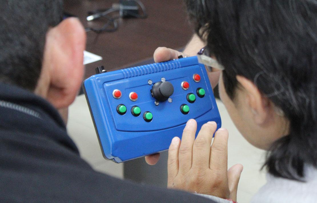 Fotografía, personas con discapacidad visual manipulando la maquina Commsiso