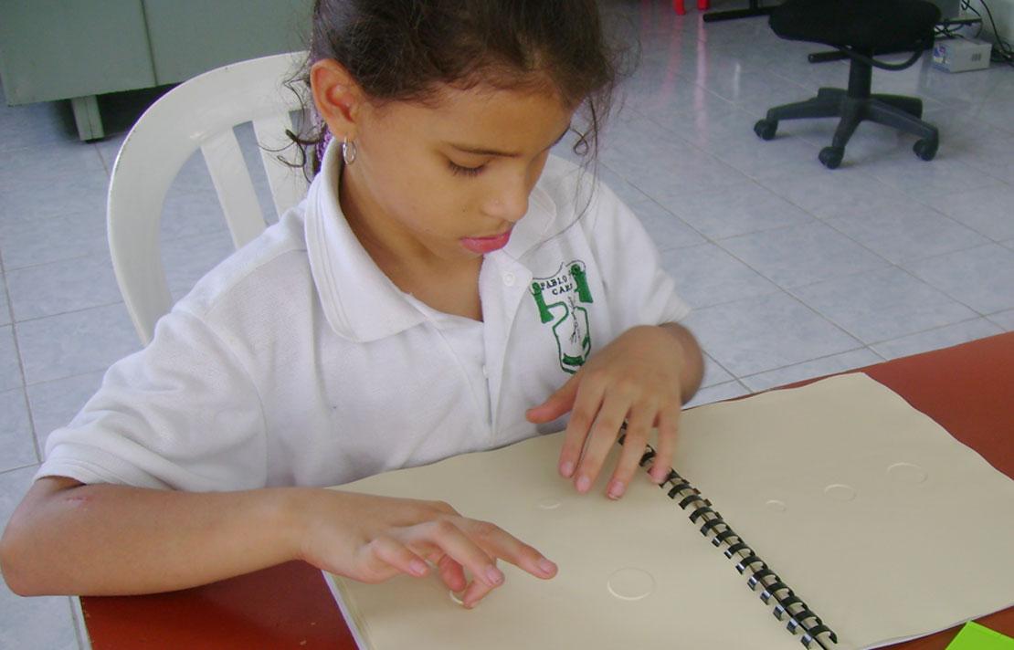 Fotografía, niña leyendo braille