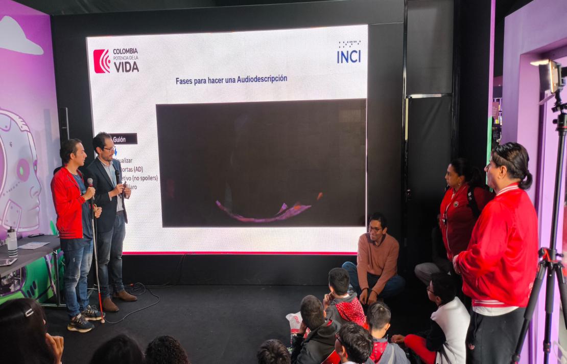 frente a una pantalla gigante están a la izquierda Camilo y Henry a la derecha está Juan Carlos Saenz funcionario del INCI junto a dos docentes, imágenes del taller