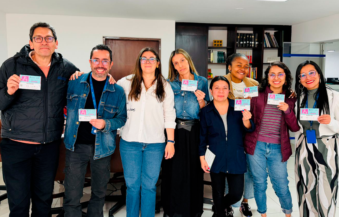 Grupo de funcionarios del INCI, acompañados por la directora Andrea Carolina Chacón, sostiene carnés de identificación durante una jornada institucional