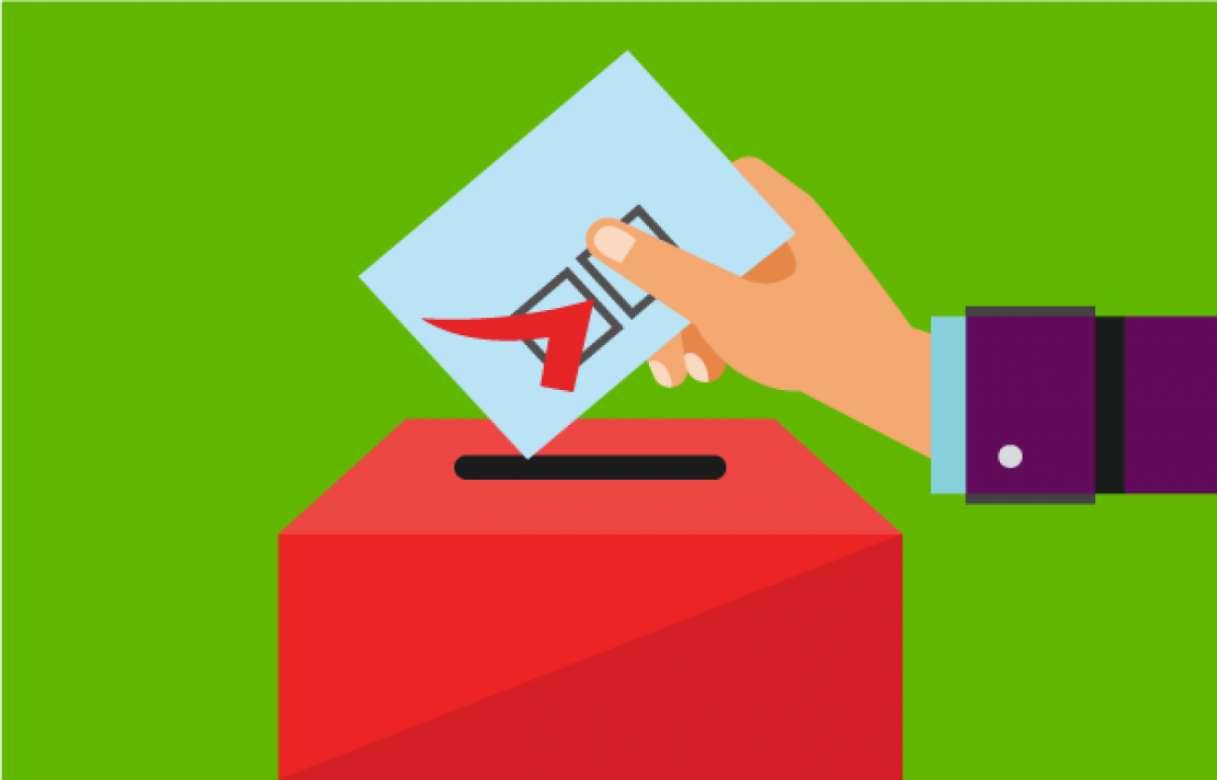 Mano depositando un voto en una urna
