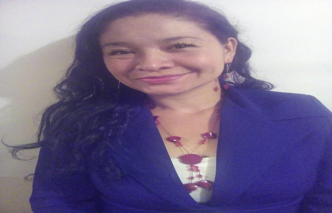 Lady sonríe, ella viste un blazer de color azul y una blusa de color blanco