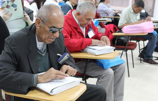 Personas con discapacidad visual leyendo en braille