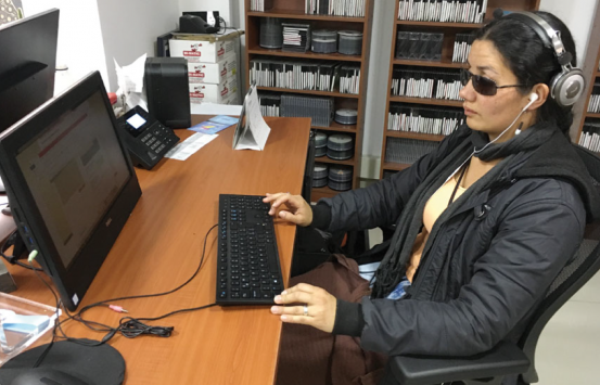 Fotografía, persona con discapacidad usando un computador