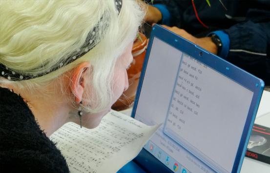 fotografía, persona con discapacidad visual leyendo en en un magnificador