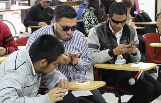 Persona con discapacidad visual, escuchando el lector de pantalla de su celular