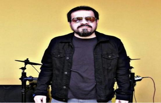 el_doctor_rock_braulio_mogollon.jpg Imagen del Doctor Rock, el está frente a una batería, él viste un buzo color vinotinto y una chamarra negra, usa unos lentes de sol