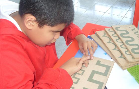 Fotografía - Niño con  discapacidad visual realizando artes manuales