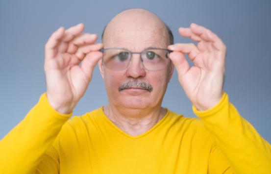 Hombre mayor revisando gafas nuevas