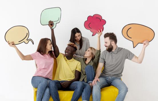 Grupo de personas sosteniendo viñetas de comics haciendo alusión a estar conversando