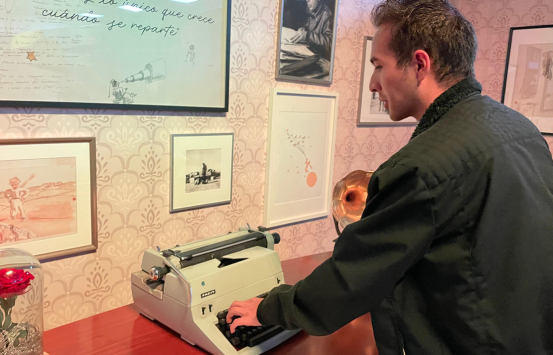 Camilo Garnica, funcionario del INCI con discapacidad visual, se ve interactuando con una maquina de escribir analoga que hace parte de la exposición del clásico literario El Principito de Antoine de Saint-Exupéry, que se encuentra abierta al público bogotano