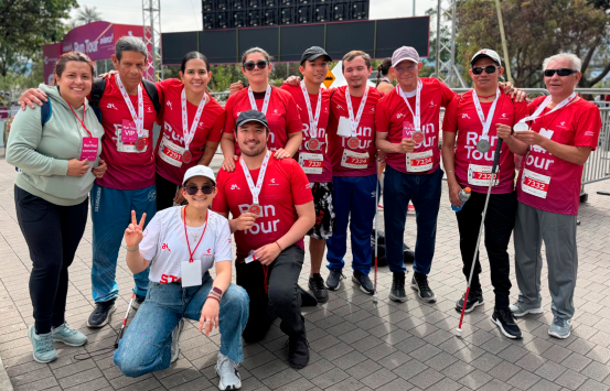 Andrea Carolina Chacón Castillo, directora general del INCI, junto a colaboradores del Instituto y participantes con discapacidad visual, posa con el grupo después de su participación en el Run Tour Avianca 2026 en Bogotá.