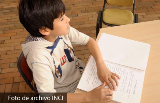 niño con discapacidad visual leyendo un texto en braille