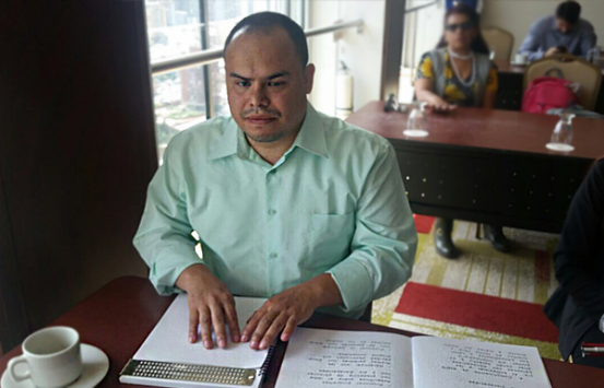 Persona con discapacidad visual, leyendo braille