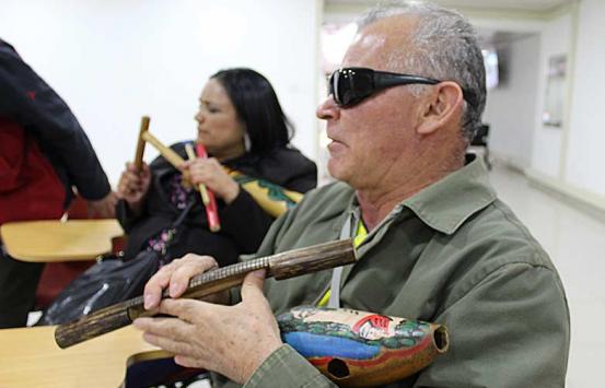 Personas con discapacidad visual, manipulando una Guacharaca