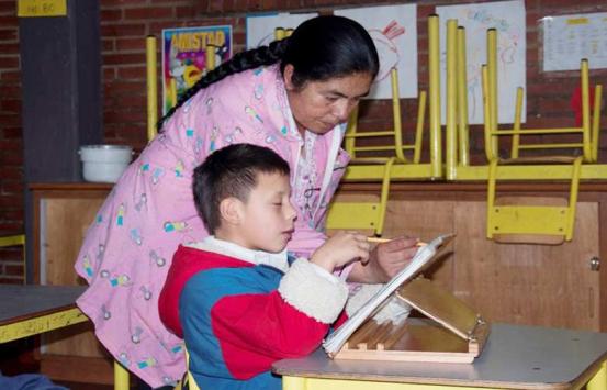 Profesora junto con un niño con discapacidad
