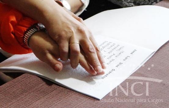 Imagen, manos leyendo braille