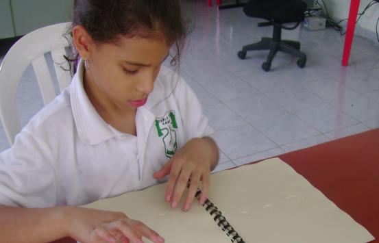 niña con discapacidad visual leyendo un texto en braille