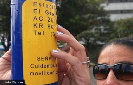 Mujer con discapacidad visual tocando una de las placas del Sistema Integrado de Transporte Público - SITP
