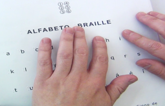 Manos de un hombre leyendo un texto en braille