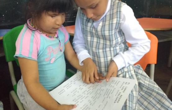 dos niñas aprendiendo a leer en braille