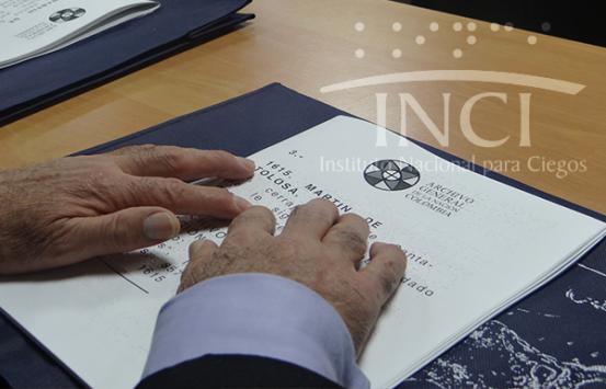 Manos sobre texto en tinta braille del Archivo General