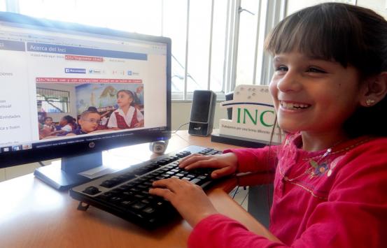 Niña con discapacidad visual utilizando un computador de escritorio