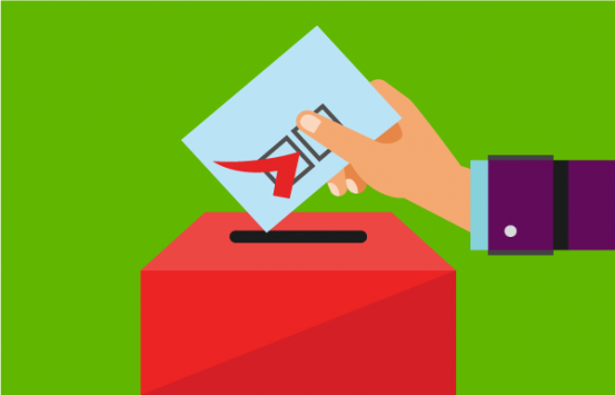 Mano depositando un voto en una urna